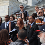 An image of Reps. Stansbury, Jackson, and Mfume, in addition to protesters, on the steps of the United States Capitol.